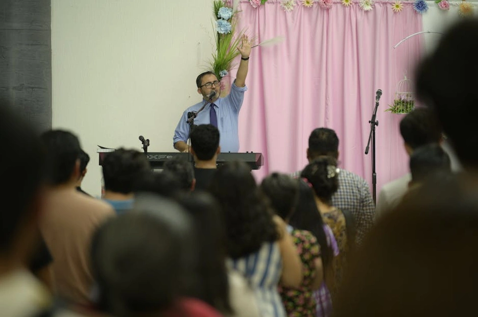 Manager che tiene un discorso motivazionale al suo team in un ufficio moderno.